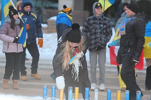 One of the attendants of Friday's march for Ukrainian solidarity places a lit candle in front of Brandon City Hall. While temperatures hovered around -20 C with the windchill, Friday's march attracted around 100 participants, some of whom included families who fled their native Ukraine to escape the ongoing war with Russia. (Kyle Darbyson/The Brandon Sun) 