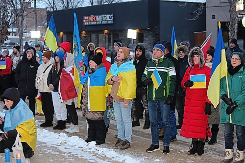 The participants of Friday's march to commemorate the one-year anniversary of Russia's invasion of Ukraine take part in the singing of the Canadian national anthem at Brandon City Hall. (Kyle Darbyson/The Brandon Sun)