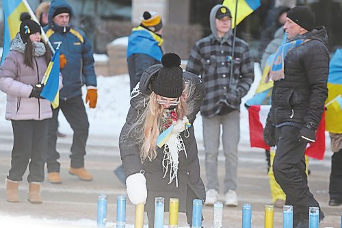 One of the attendants of Friday's march for Ukrainian solidarity places a lit candle in front of Brandon City Hall. While temperatures hovered around -20 C with the windchill, Friday's march attracted around 100 participants, some of whom included families who fled their native Ukraine to escape the ongoing war with Russia. (Kyle Darbyson/The Brandon Sun) 