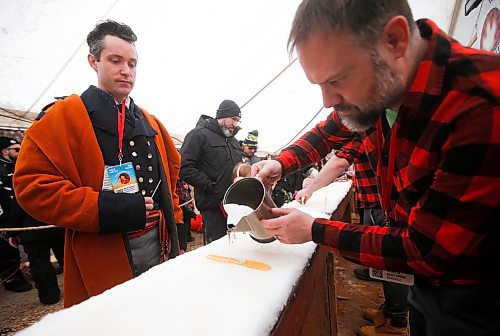 JOHN WOODS / WINNIPEG FREE PRESS
Marc Gilbert pours maple syrup for Darrel Nadeau, executive director of Festival du Voyageur, on the last day of the festival Sunday, February 26, 2023. 

Re: macintosh