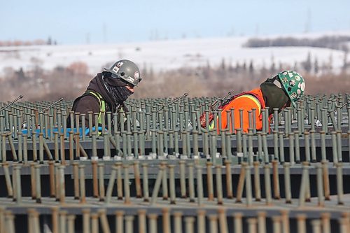A pair of construction workers are lost in a sea of metal pins that grace the top of recently installed metal beams spanning the new section of the Daly Overpass on Wednesday afternoon. (Matt Goerzen/The Brandon Sun)