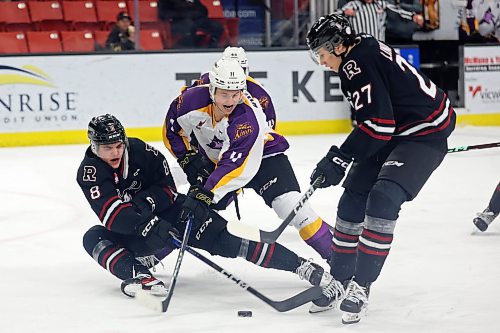 Brandon Wheat Kings forward Rylen Roersma, centre, tries to slip the puck between Jace Weir, left, and Mats Lindgren of the Red Deer Rebels during WHL action at Westoba Place on Friday evening. (Tim Smith/The Brandon Sun)