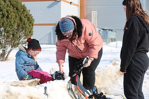 Krystal Negraeff helps her daughter Charlotte put on some snowshoes during Saturday's Winter Fest activities, which took place in and around Brandon's Community Sportsplex. (Kyle Darbyson/The Brandon Sun) 