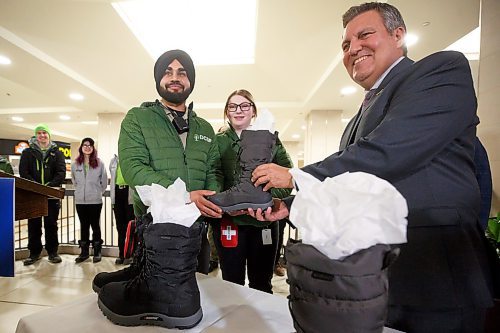 Mike Deal / Winnipeg Free Press
Finance Minister Cliff Cullen rather than purchase a new pair of shoes prior to budget day, as is tradition, instead has two pairs of winter boots that he is giving to members of the Downtown Community Safety Partnership (DCSP) to distribute to program participants in downtown Winnipeg who do not have proper winter footwear. During a media event held at CityPlace Shopping Centre Monday morning he gave the boots to Karanbir Rangi (left) and Erika Erickson (centre) who are with the DCSP MAC 24/7 team.
230306 - Monday, March 6, 2023