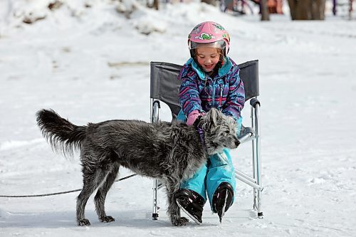 10032023
Five-year-old Claire Dagg visits with her grandfathers dog Piper while ice skating on Minnedosa Lake with her grandfather Tom Instance on a mild Friday. (Tim Smith/The Brandon Sun)