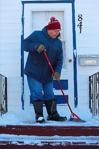 Brandon resident Kerry Fast sweeps some snow off his front steps Sunday morning in the wake of a major blizzard that dumped a significant amount of snow on the city the previous day. (Kyle Darbyson/The Brandon Sun)