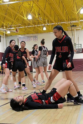 Sisler Spartans Bea Carino lies on the ground after drawing an offensive foul while Alyssa Doneza steps in to help her up and the Westwood Warriors walk away in the AAAA provincial varsity girls' basketball quarterfinals at Crocus Plains on Sunday. The Spartans upset the Warriors to reach a semifinal against Dakota, which defeated Kelvin 108-22. Garden City defeated River East to reach the other semifinal. The evening contest between Vincent Massey (Winnipeg) and Fort Richmond was in progress at press time. (Thomas Friesen/The Brandon Sun)