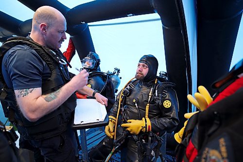 Sgt. Greg Fast with Saskatchewan RCMP reviews details with Cpl. Justin Nichols with Manitoba RCMP prior to Nichols' dive during ice diving re-qualification for members of Manitoba and Saskatchewan’s RCMP dive teams at Clear Lake in Riding Mountain National Park on Tuesday. (Tim Smith/The Brandon Sun)