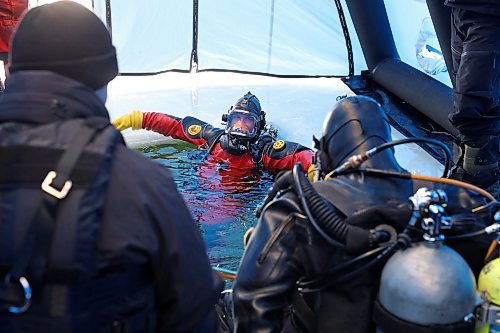Sgt. Will Picard with Saskatchewan RCMP and Cpl. Justin Nichols with Manitoba RCMP get into the water to take turns doing searches for each other during ice diving re-qualification for members of Manitoba and Saskatchewan’s RCMP dive teams at Clear Lake in Riding Mountain National Park on Tuesday. (Tim Smith/The Brandon Sun)