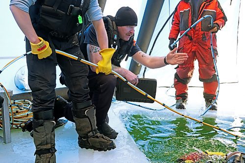 Sgt. Greg Fast with Saskatchewan RCMP instructs a diver during ice diving re-qualification for members of Manitoba and Saskatchewan’s RCMP dive teams at Clear Lake in Riding Mountain National Park on Tuesday. (Tim Smith/The Brandon Sun)