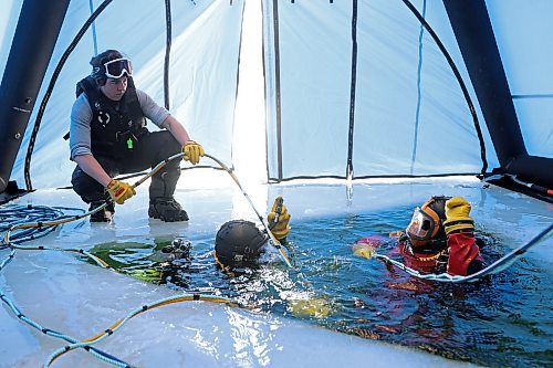 Const. Caro Giroux with Saskatchewan RCMP holds lines as two divers prepare to descend under the ice during ice diving re-qualification for members of Manitoba and Saskatchewan’s RCMP dive teams at Clear Lake in Riding Mountain National Park on Tuesday. (Tim Smith/The Brandon Sun)