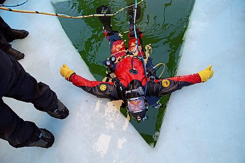 15032022
Sgt. Will Picard with RCMP Saskatchewan rests against the ice while waiting to do an underwater search during ice diving re-qualification for members of Manitoba and Saskatchewan&#x2019;s RCMP dive teams at Clear Lake in Riding Mountain National Park on Tuesday. 
(Tim Smith/The Brandon Sun)