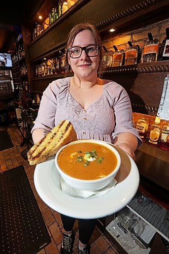 15032023
Geneva Frank, floor manager with The Dock on Princess holds the local pub&#x2019;s spicy beer cheddar soup. Until this coming Sunday the Dock will donate $1 from every bowl of their spicy cheddar soup sold to the Stone Soup fundraiser which supports various meal and snack programs in Brandon schools. 
(Tim Smith/The Brandon Sun)