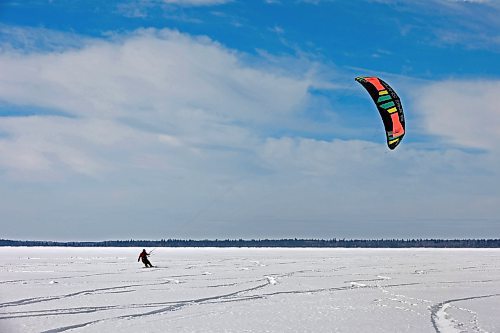 Ryan Murray of Onanole snowkites across Clear Lake at Riding Mountain National Park on a windy Tuesday afternoon. Murray offers snowkiting lessons through the Friends of Riding Mountain National Park. Snowkiting is using a kite and the power of the wind to glide across snow and ice on a snowboard. (Tim Smith/The Brandon Sun)