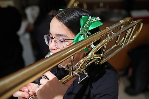 Lyla Briol with Brandon’s Vincent Massey High School Junior Jazz Band plays the trombone with St. Patrick’s Day bows in her hair while warming up with band-mates prior to performing during the Brandon University Jazz Festival at the Brandon University School of Music on Friday. The three day festival, the first since 2019 due to the COVID-19 pandemic, brought in school bands from across the province for performances and workshops throughout the WMCA and Brandon University. The festival wraps up today.
(Tim Smith/The Brandon Sun)