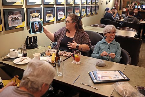 15032023
Karlie Mymryk holds up an ipad with a video call with friend Allison Danielson, who moved away from Brandon, so Danielson can still socialize with her knitting circle at Tavern United in the Canad Inns Hotel in Brandon on Wednesday evening. 
(Tim Smith/The Brandon Sun)