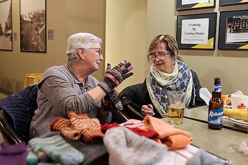 15032023
Mona Koroscil shows a pair of mitts she made to friend Judy Dandridge during a weekly knitting evening among friends at Tavern United in the Canad Inns Hotel in Brandon on Wednesday evening. 
(Tim Smith/The Brandon Sun)