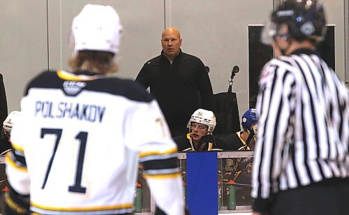 Dan Block, framed by Brandon Wheat Kings forward Zakhar Polshakov and an official, stands on the bench during the final game of training camp at J&G Homes Arena on Sept. 5, 2022. The recently retired Mountie from Red Deer has maintained a close bond with the team he first volunteered with at the 2016 Memorial Cup. (Perry Bergson/The Brandon Sun)
