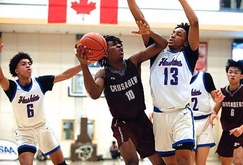 JOHN WOODS / WINNIPEG FREE PRESS
Sturgeon Heights Huskies&#x2019; Elijah De La Mothe (6) and Noah Kankam (13) defend against St Paul&#x2019;s Crusaders&#x2019; Giovanni Ajiamah (10) in the Manitoba High School 2023 AAAA Provincial Basketball Championship at the University of Manitoba Monday, March 20, 2023. 