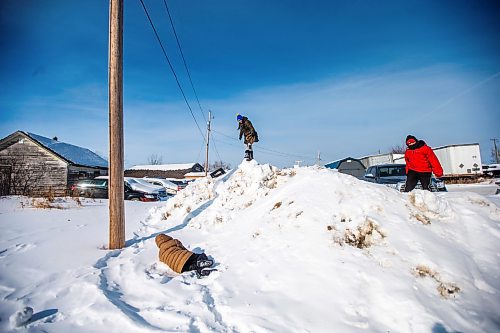 MIKAELA MACKENZIE / WINNIPEG FREE PRESS

Harry Jr. Cook (left), Trudy Duck, and Hughie Goosehead play on a heap of snow after going on a sled dog ride with the school program on Bloodvein First Nation on Wednesday, March 8, 2023. For Maggie Macintosh story.

Winnipeg Free Press 2023.