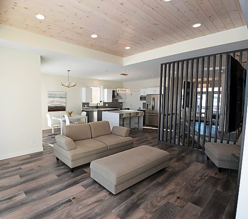 Todd Lewys / Winnipeg Free Press
Warm wide plank vinyl flooring, a tray ceiling and a vertical slat feature wall add style, texture and warmth to the naturally bright main living area.
