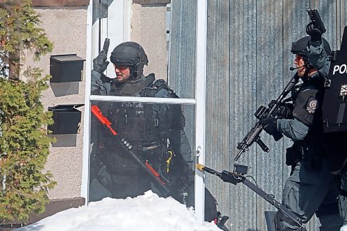 23032023
Members of the Brandon Police Service enter a home in the 300 block of 11th Street in Brandon with guns drawn on Thursday. (Tim Smith/The Brandon Sun)