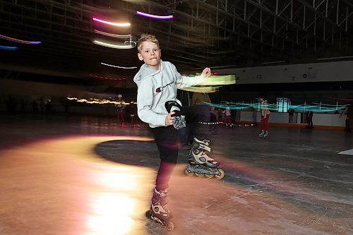 23032023
Grayson Swain stunts while roller-skating during Roller Disco at the Sportsplex Arena on Thursday evening. The Wheat City Roller derby League was on hand to rent skates to interested roller-skaters without their own pair. Dozens of roller-skating enthusiasts were already in line before the event started and spent the event skating to music under the colourful lights and disco ball. 
(Tim Smith/The Brandon Sun)