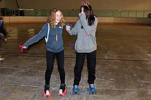 23032023
Athena Ringland and Leah Thurston roller-skate during Roller Disco at the Sportsplex Arena on Thursday evening. The Wheat City Roller derby League was on hand to rent skates to interested roller-skaters without their own pair. Dozens of roller-skating enthusiasts were already in line before the event started and spent the event skating to music under the colourful lights and disco ball. 
(Tim Smith/The Brandon Sun)