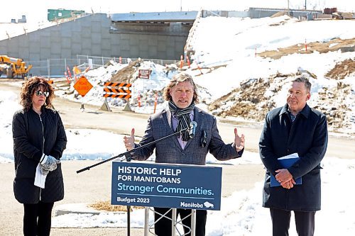27032023
Tanya LaBuick, President of the Brandon Chamber of Commerce, listens as City of Brandon Mayor Jeff Fawcett speaks after Transportation and Infrastructure Minister Doyle Piwniuk made an infrastructure announcement on 17th Street North in front of the ongoing 18th Street Bridge construction on Monday. (Tim Smith/The Brandon Sun)