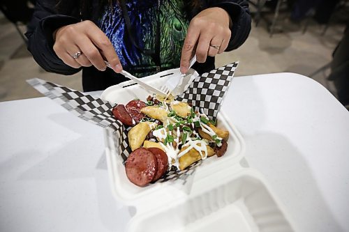A customer digs into some freshly made perogies and sausage from a stall at the Royal Food Court in the Keystone Centre's Manitoba Room during the Royal Manitoba Winter Fair. (Matt Goerzen/The Brandon Sun)