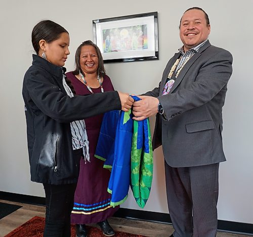 Molly Taylor (right), daughter of Chief Lola Thunderchild of Canupawakpa Dakota Nation (centre), presents Jerry Daniels, grand chief of the Southern Chiefs' Organization, with a star blanket at the organization's office in downtown Brandon on Thursday. (Miranda Leybourne/The Brandon Sun)