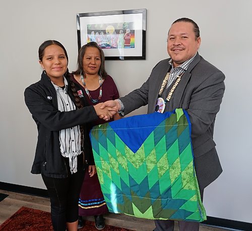 Molly Taylor (right), daughter of Chief Lola Thunderchild of Canupawakpa Dakota Nation (centre), presents Jerry Daniels, grand chief of the Southern Chiefs' Organization, with a star blanket at the organization's office in downtown Brandon on Thursday. (Miranda Leybourne/The Brandon Sun)
