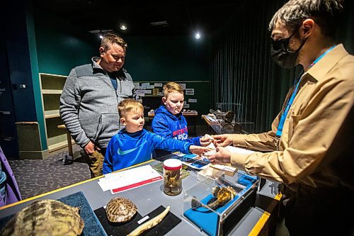 MIKAELA MACKENZIE / WINNIPEG FREE PRESS

Learning and engagement producer Erin Buelow shows Stannis Rekdal (six, left), Thorian Rekdal (ten), and their dad Brad Rekdal cone snail shells in the special &#x4a9;nvestigate aquatic animals&#x4e0;section of the museum as part of the spring break activities at the Manitoba Museum in Winnipeg on Thursday, March 30, 2023.  This pop-up celebrates biodiversity, and runs during spring break and weekend afternoons in April. Standup.

Winnipeg Free Press 2023.