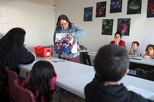 Julia Brandon of Wawezhiicabbo Wing shows students historical photos of her relatives in residential schools while teaching her weekly Anishinaabemowin language class at the Brandon Friendship Centre on Friday. The two-hour class each Friday afternoon is part of the '60s Scoop Reclaim and Reconnect program. (Tim Smith/The Brandon Sun)