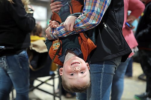 Averi Jury holds Declan Steppler upside down while playing with him at the Royal Manitoba Winter Fair in the Keystone Centre on Friday. (Tim Smith/The Brandon Sun)
