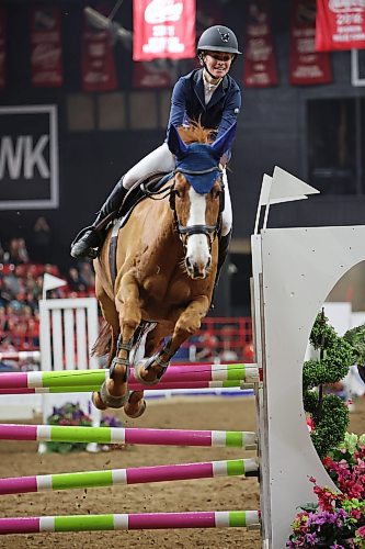 Karly Woods leaps over a fence atop Maverick during the Playnow Challenge Cup evening show-jumping event at the Royal Manitoba Winter Fair in Westoba Place on Friday. (Tim Smith/The Brandon Sun)
