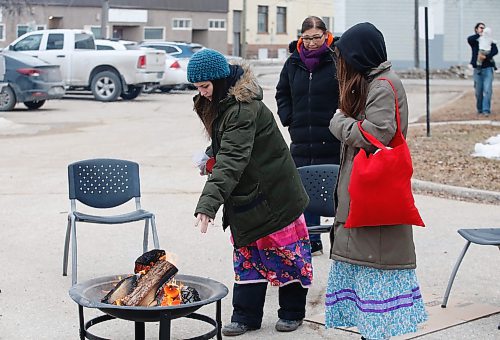JOHN WOODS / WINNIPEG FREE PRESS
Canbria Harris, left, and her sister Elle, daughters of Morgan Harris, put tobacco in a fire as people gather to remember Linda Mary Beardy whose body was found in Brady Landfill Tuesday, April 4, 2023. 

Re: May