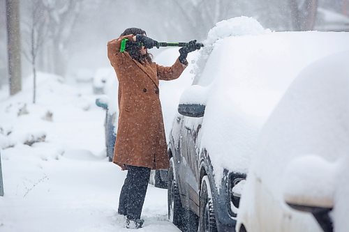 Mike Deal / Winnipeg Free Press
Kirsten Savignac clears off her car as Winnipeggers dig out of an April snow storm Wednesday morning.
230405 - Wednesday, April 05, 2023.