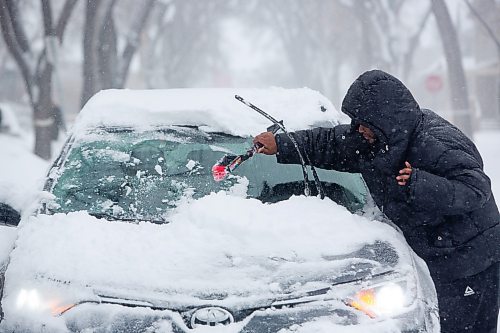 Mike Deal / Winnipeg Free Press
Jr. Munyaka clears off his car as Winnipeggers dig out of an April snow storm Wednesday morning.
230405 - Wednesday, April 05, 2023.