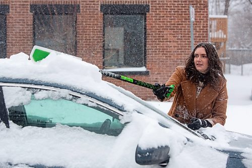 Mike Deal / Winnipeg Free Press
Kirsten Savignac clears off her car as Winnipeggers dig out of an April snow storm Wednesday morning.
230405 - Wednesday, April 05, 2023.