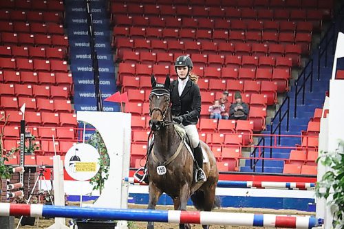 Tyne Alliban competes in a jumping competition at Westoba Place March 30 alongside her thoroughbred Stormy Spirited. Alliban and her family travelled all the way from Carstairs, Alta. to take part in this year's Royal Manitoba Winter Fair Horse Show. (Kyle Darbyson/The Brandon Sun)
