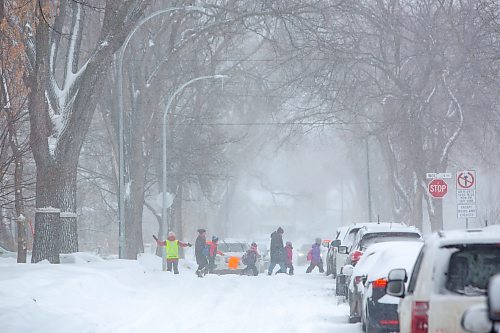 Mike Deal / Winnipeg Free Press
Crossing guards wave on parents walking their children to school as Winnipeggers dig out of an April snow storm Wednesday morning.
230405 - Wednesday, April 05, 2023.