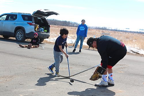 Sioux Valley Dakota Nation resident Brody Hanska rushes Dryden Gage during a game of ball hockey as Nash Ironman and Douglas Hanska watch in the background. (Kyle Darbyson/The Brandon Sun)