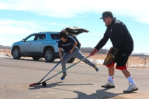 Brody Hanska rushes Dryden Gage during a game of ball hockey that took place Monday afternoon during Sioux Valley Dakota Nation's Spring Carnival event. (Kyle Darbyson/The Brandon Sun)