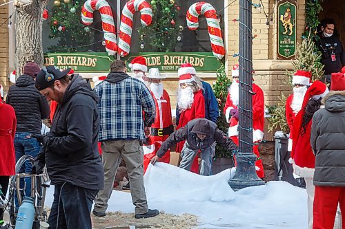 Mike Deal / Winnipeg Free Press
Crews add more &#x201c;snow&#x201d; to the street full of Santas who gathered at Albert Street and McDermot Avenue Monday morning during the last days of filming the Hallmark film, The Santa Summit. Production was scheduled to take place between March 24 and April 13 in Winnipeg. The feature film is about a group of friends who turn to each other for support and during the annual Santa Summit &#x201c;discover the magic of taking big chances and being vulnerable.&#x201d;
230410 - Monday, April 10, 2023.