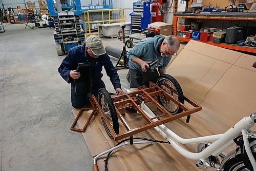 Alex Jarema (left) and Steve Gale (right), both former members of the Neepawa Kin Club, put together a trishaw bicycle for Neepawa's Cycling Without Age chapter on April 11. (Miranda Leybourne/The Brandon Sun)