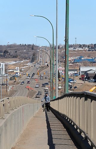 Brandon resident Dustin Melnick pushes his bike up the walkway on the north side of the Daly Overpass along 18th Street on Tuesday morning. (Matt Goerzen/The Brandon Sun)