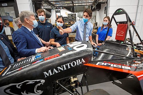 Mike Deal / Winnipeg Free Press
Prime Minister Justin Trudeau gives a thumbs up to MP Terry Duguid (left) while chatting with engineering students Brett Stevens (second from left) Nivida Mishra (left of Trudeau) and Emma Mctavish (right) who are showing him an EV race car that is being built in the Stanley Pauley Engineering Building at the UofM Fort Garry campus Wednesday morning. The PM is in town to announce Budget 2023 measures to help build a clean economy and visit with engineering students at the UofM Wednesday morning.
230412 - Wednesday, April 12, 2023.