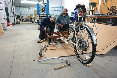 Alex Jarema (left) and Steve Gale (right), both former members of the Neepawa Kin Club, put together a trishaw bicycle for Neepawa's Cycling Without Age chapter on April 11. See story on Page 2. (Miranda Leybourne/The Brandon Sun)