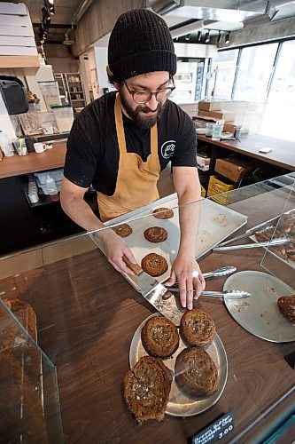 Mike Deal / Winnipeg Free Press
Max Palay puts fresh Brown Butter Chocolate Chip Cookies on display.
Friends Max Palay and Drew McGillawee have opened a new bakery by day and pizza shop by night in South Osborne, Friend Bakery and Pizza, 380 Osborne Street. 
230413 - Thursday, April 13, 2023.